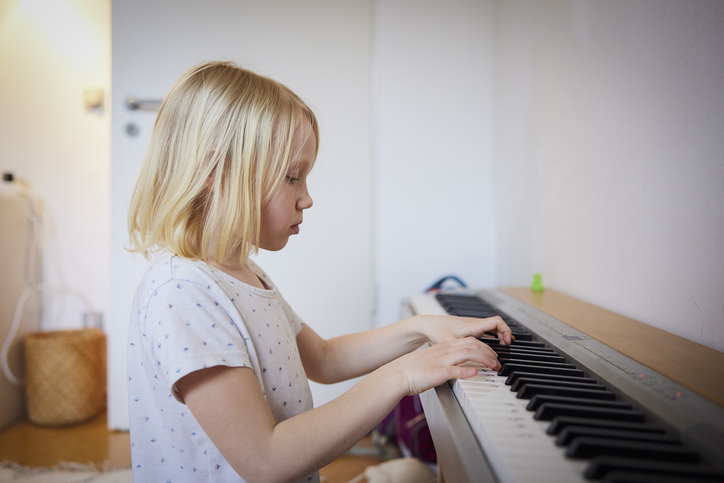 家でピアノを弾く女の子の横顔